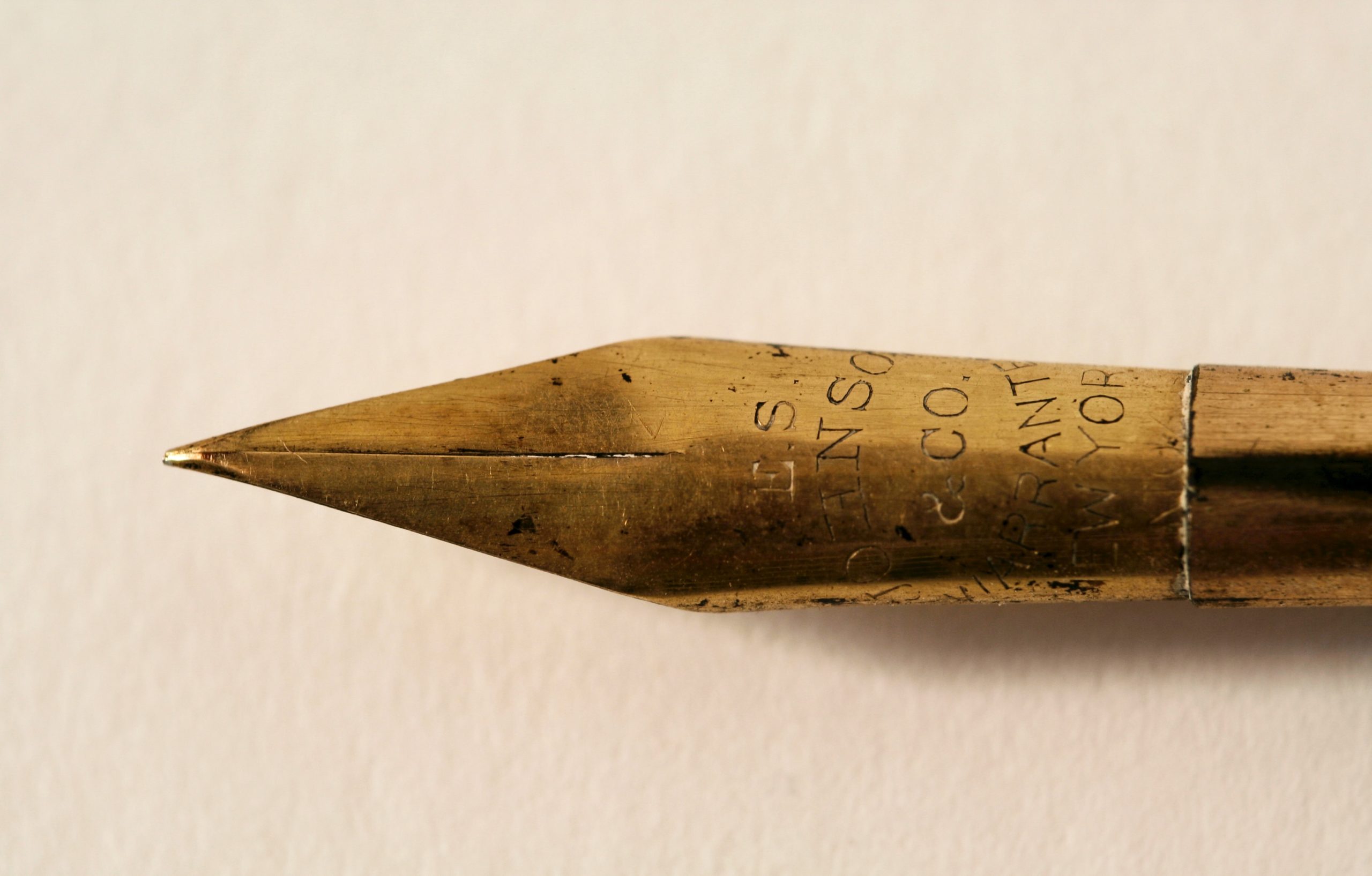 Photo par MJ S closeup photo of gold fountain pen